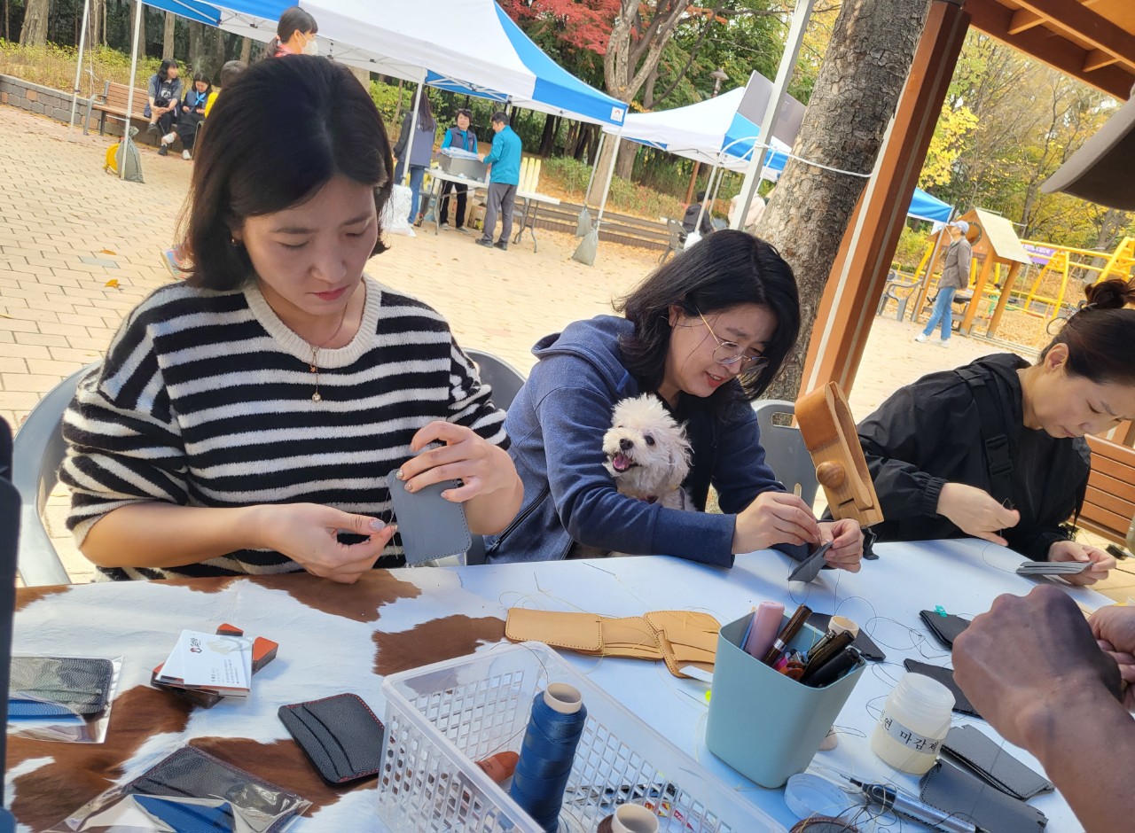 강아지와 함께 야외에서 가죽공예를 즐기는 모습