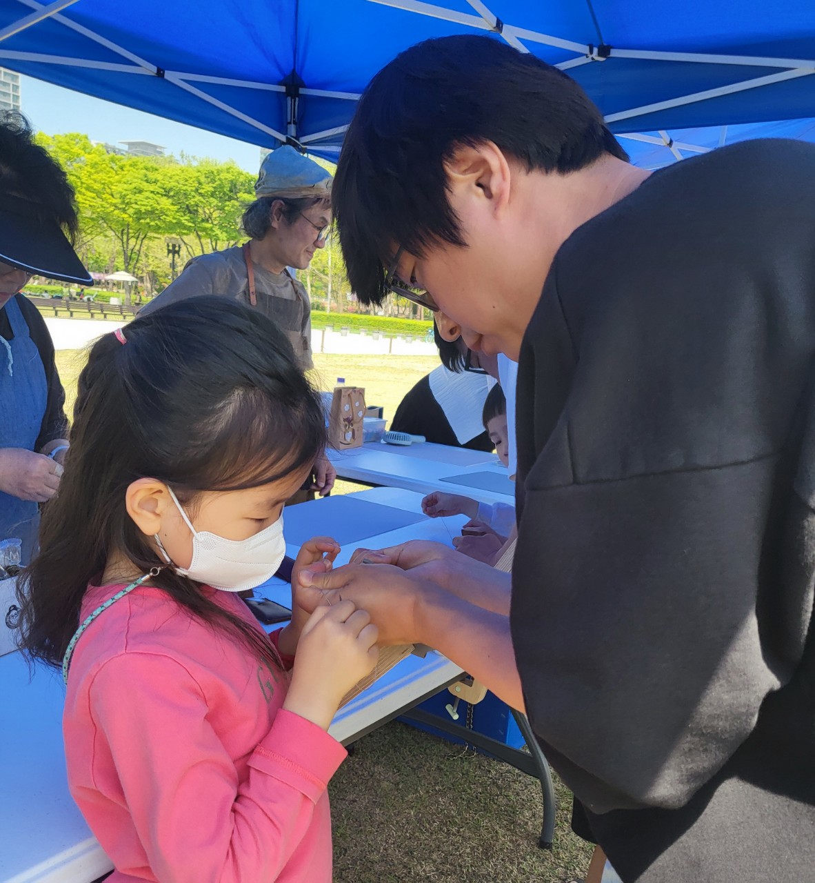 청소년들이 함께 가죽공예 작품을 완성하는 모습
